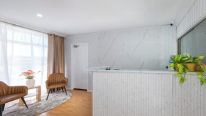 A modern kitchen with a marble backsplash, wooden cabinets, and a built-in island with a sink. - Rainbow Motel Queanbeyan (Queanbeyan East)