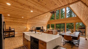 Une cabine spacieuse comprenant une cuisine, un coin repas et de grandes fenêtres offrant une vue sur l’extérieur.