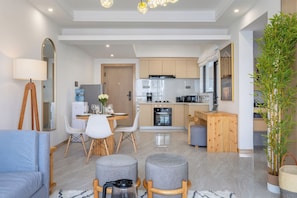 A modern living room with a sofa, a coffee table, and a dining area with a table and chairs. - Leshwa Delight by YourHost 1B Kileleshwa (Nairobi)