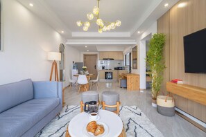 A modern living room with a sofa, coffee table, and a dining area with chairs and a table. - Leshwa Delight by YourHost 1B Kileleshwa (Nairobi)