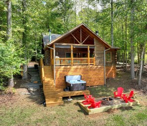 A cabin with a porch, a fire pit, and outdoor seating. - Pet-friendy, lake-front cabin rental with outdoor fireplace, dock w/Jon Boat (Ellijay)