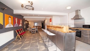 A modern kitchen with a central island, bar stools, and a dining area with a table and chairs. - higgihaus 5 5 of 7 Rooms Monday - Friday (Cardiff)