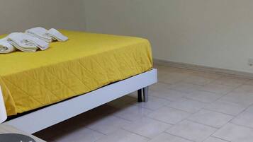 Une petite pièce lumineuse, avec un lit, une petite table et une lucarne.