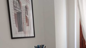 En matplats med ett bord, stolar, en inramad tavla på väggen och ett glas som innehåller sugrör.