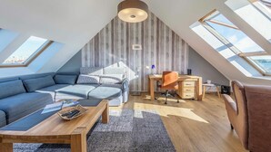 A modern loft bedroom with skylights, a loft bed, a desk, and a sofa. - "Seeblick" Vacation Rental at the Marina with a View of Lake Müritz (Waren (Müritz))