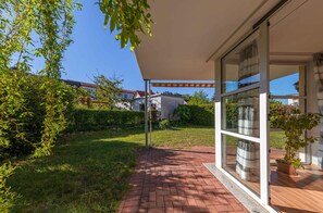 Enjoy the serene atmosphere of this outdoor space with a brick pathway leading to a covered patio area.