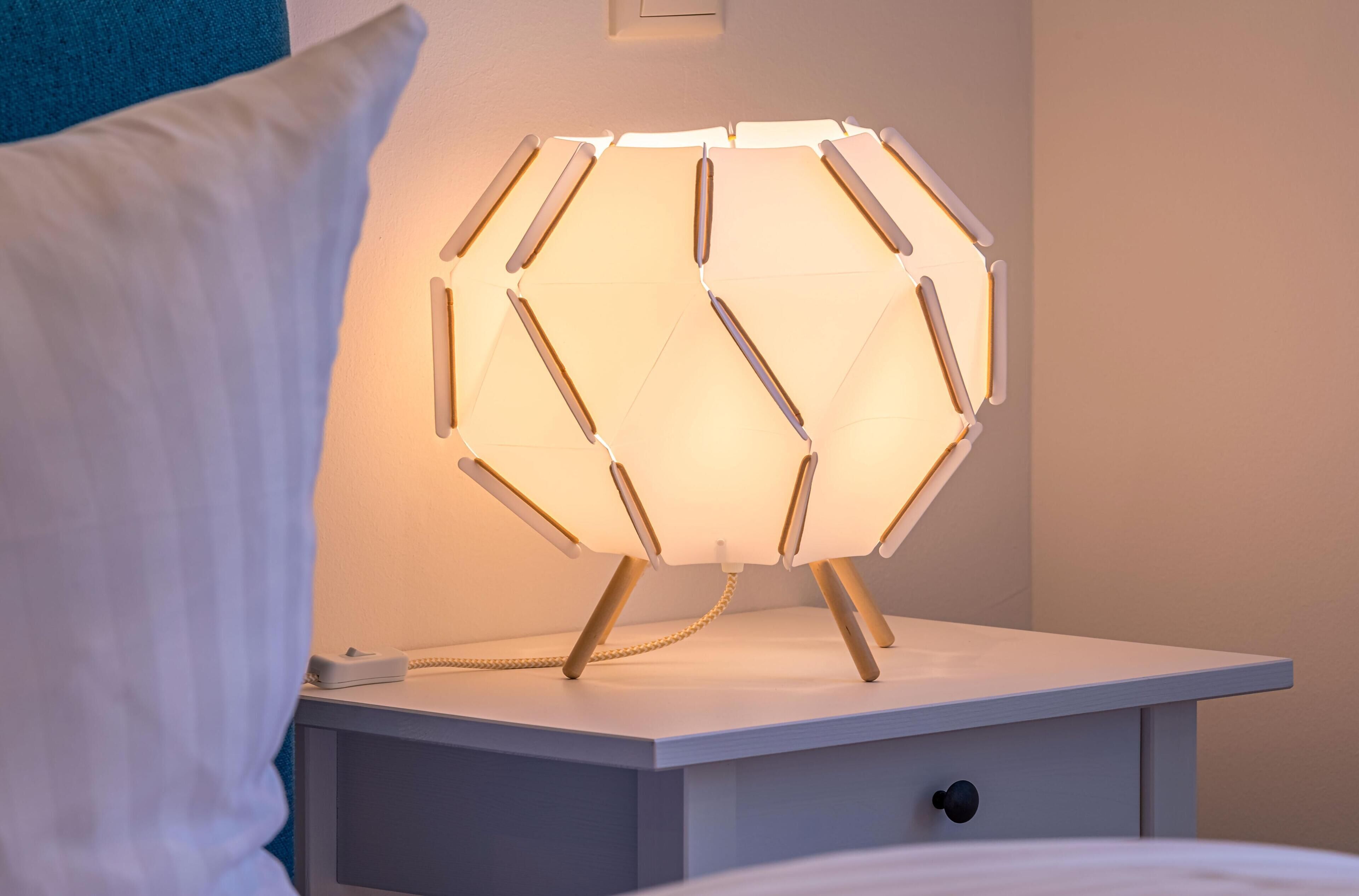 Ein Nachttisch mit einer sechseckigen Lampe und einer Schublade.