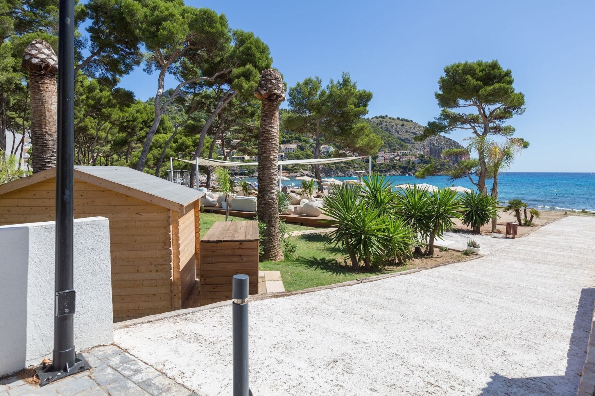 A beachside property with a wooden cabin, a hammock, and a view of the sea.