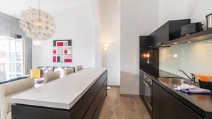 A modern kitchen with a central island, dark cabinetry, and a large window providing natural light. - Vacation apartment "Kietz-Quartier" in the historic Kietzspeicher in Waren (Müritz) (Waren (Müritz))
