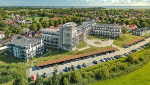 Eine Luftaufnahme eines großen Gebäudekomplexes mit mehreren Gebäuden, einem Parkplatz und umliegender Bepflanzung.