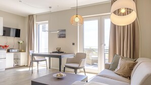 Un salon moderne avec un canapé, une table basse et un coin repas.