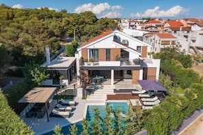Ein modernes Haus mit Swimmingpool, Außenbereich und Blick auf die umliegende Nachbarschaft.
