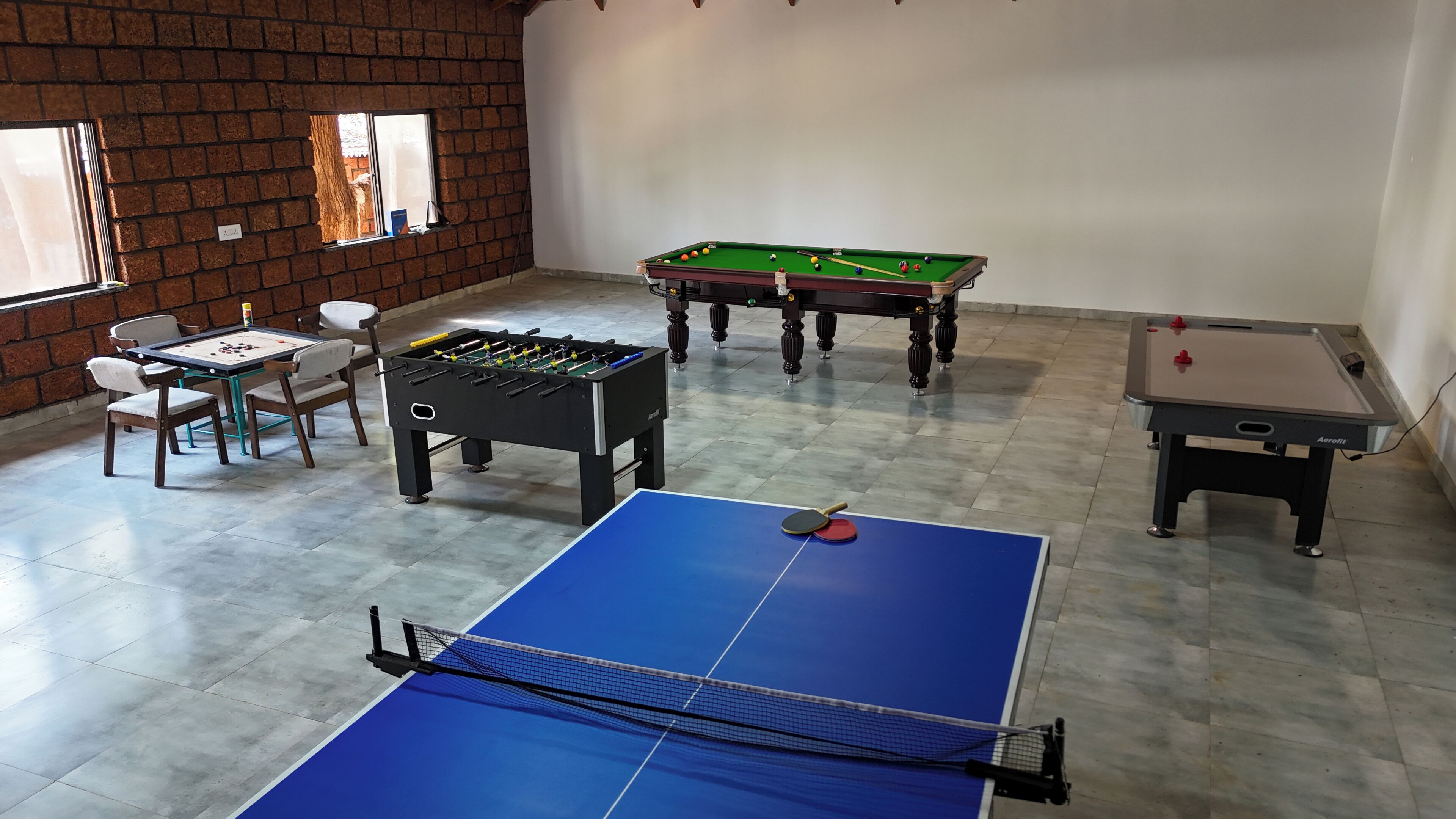 Ein Raum mit Kicker, Billardtisch und Tischtennisplatte.