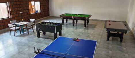 Ein Raum mit Kicker, Billardtisch und Tischtennisplatte.