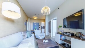 Un salon moderne avec un canapé, une table basse et un téléviseur fixé au mur.