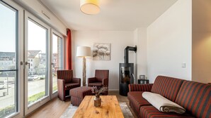 Una sala de estar moderna con un sofá, sillones, una mesa de centro y una chimenea.