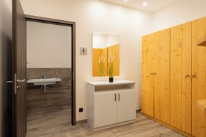 A bathroom with a wooden cabinet, a sink, and a mirror.
