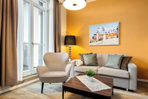 Ein Wohnzimmer mit einer Couch, einem Sessel und einem Couchtisch mit einer Pflanze.