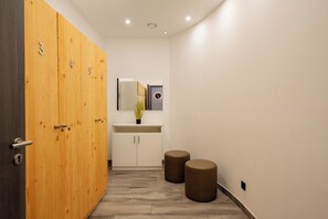 Ferienwohnung First Garden View Wustrow – moderner Umkleidebereich mit Holzspinden und stilvoller Beleuchtung