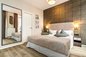 A modern bedroom with a large bed, bedside lamps, a mirror, and a view of the outdoors. - First Garden View Vacation Apartment in Wustrow, a quiet location near the Baltic Sea (Wustrow)