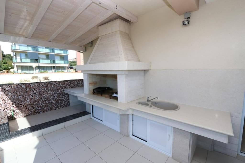A modern kitchen with a built-in oven, a sink, and a stone backsplash.
