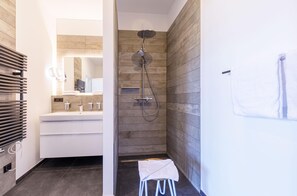 A modern bathroom with a shower, a sink, and a towel rack. - Apartment Backboard in the main house with balcony (Wustrow)