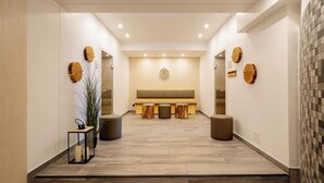 A modern reception area with a bench, wooden stools, and a potted plant. - "Vitus Bering Suite" Vacation Rental with a Balcony on the Baltic Sea (Wustrow)