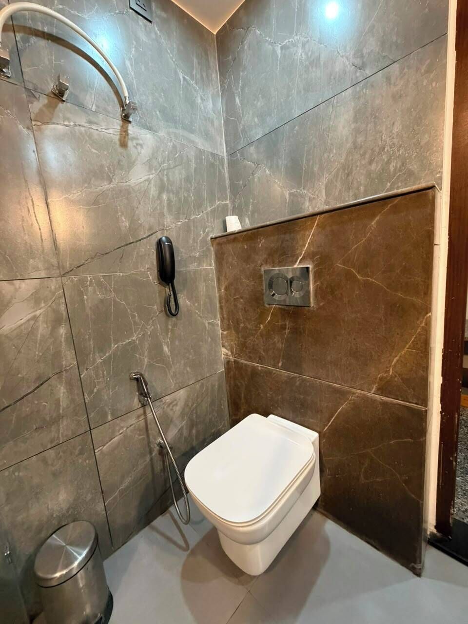 A bathroom with a toilet, a shower, and a hand dryer.