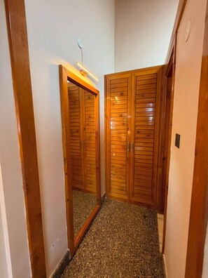 A hallway with wooden doors and a mirror on the wall. - The Uttrayan (Chakrata)