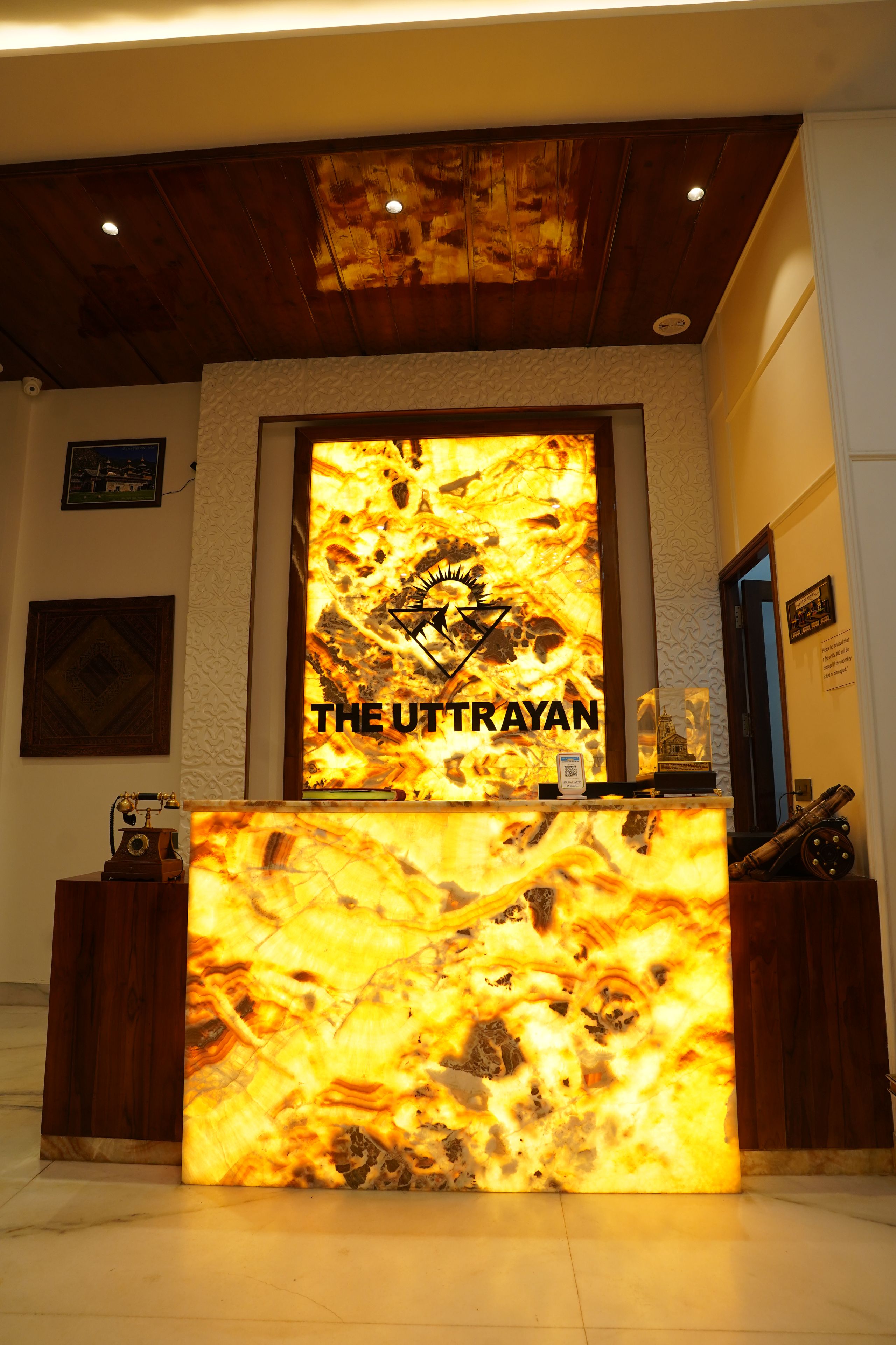 A reception desk with a large illuminated sign reading 'THE UTTRAYAN'.
