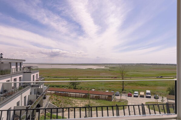 Vista desde un balcón sobre un estacionamiento, con un río al fondo.