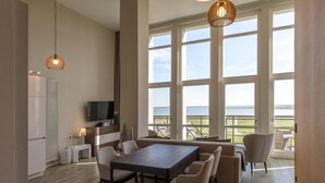 Una cocina moderna con comedor, ventanas amplias y vista al mar.