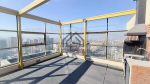 En hög byggnad med en inglasad terrass som erbjuder en fantastisk panoramautsikt över staden.