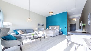 Ein modernes Wohnzimmer mit einer Couch, Sesseln, einem Couchtisch und einem Esstisch.