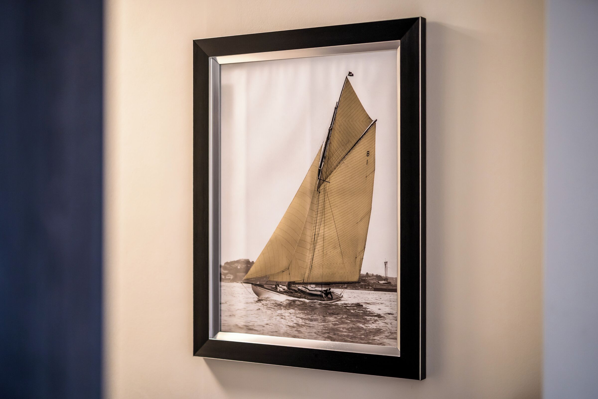 A framed photograph of a sailboat on water.