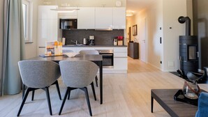 A modern kitchen with white cabinets, a central island, and a built-in stove. - 5 star vacation apartment "Seestern" between the Baltic Sea and the Bodden (Wustrow)