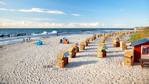 A beach with rows of beach huts and a lifeguard tower. - 5 star vacation apartment "Seesinn" in Wustrow on the Baltic Sea (Wustrow)