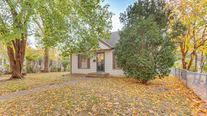 A house with a front yard covered in fallen leaves, surrounded by trees and a fence. - 7 Mi to Downtown Minneapolis: Home w/ Fire Pit! (Richfield)