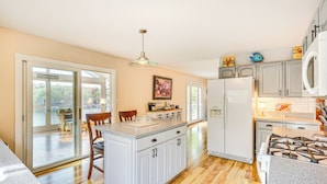 A kitchen with a central island, white cabinets, a refrigerator, and a stove. - 'the Waterfront Gem' w/ Dock in Osage Beach! (Osage Beach)