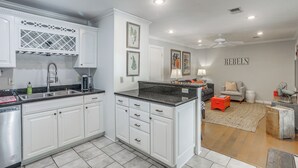 A modern kitchen with white cabinetry, a granite countertop, and a built-in oven. - Private Deck, 1 Block From The Square (Oxford)