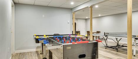 Ett rum med ett fotbollsspel, ett bordtennisbord och en stor spegel.