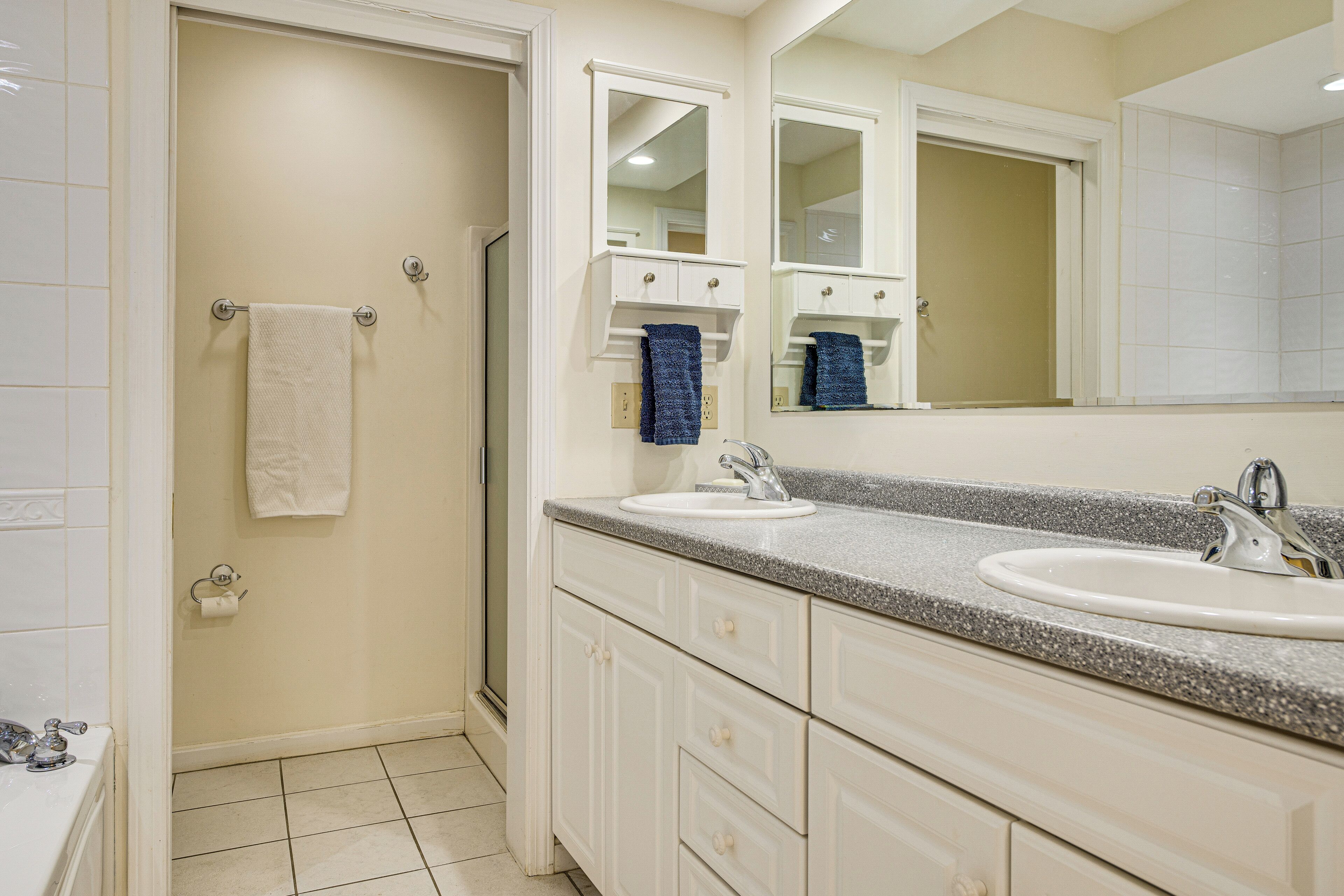 Une salle de bain avec deux lavabos, un miroir et un porte-serviettes.