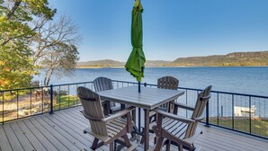 A deck with a table and chairs overlooking a lake. - Dock & Views: Waterfront Home in Wabasha! (Wabasha)