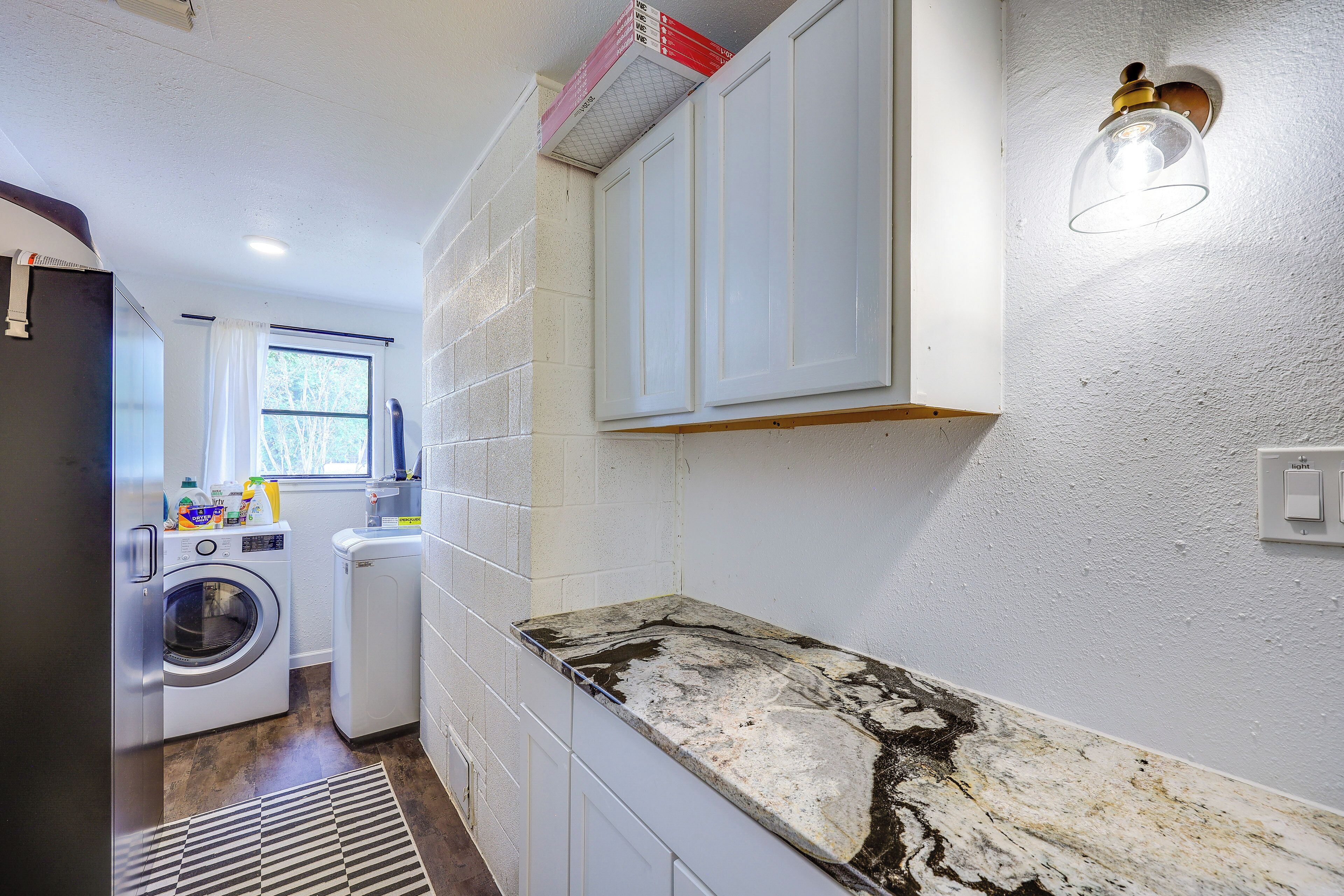 A laundry room with a washing machine, dryer, and stacked laundry baskets.