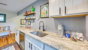 A kitchen with white cabinets, a granite countertop, a stainless steel sink, and a coffee maker. - < 1 Mi to Dtwn: Home w/ Fenced Yard in Boerne! (Boerne)