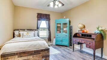 A bedroom with a wooden bed, a teal cabinet, and a desk with a globe and a toy car.
