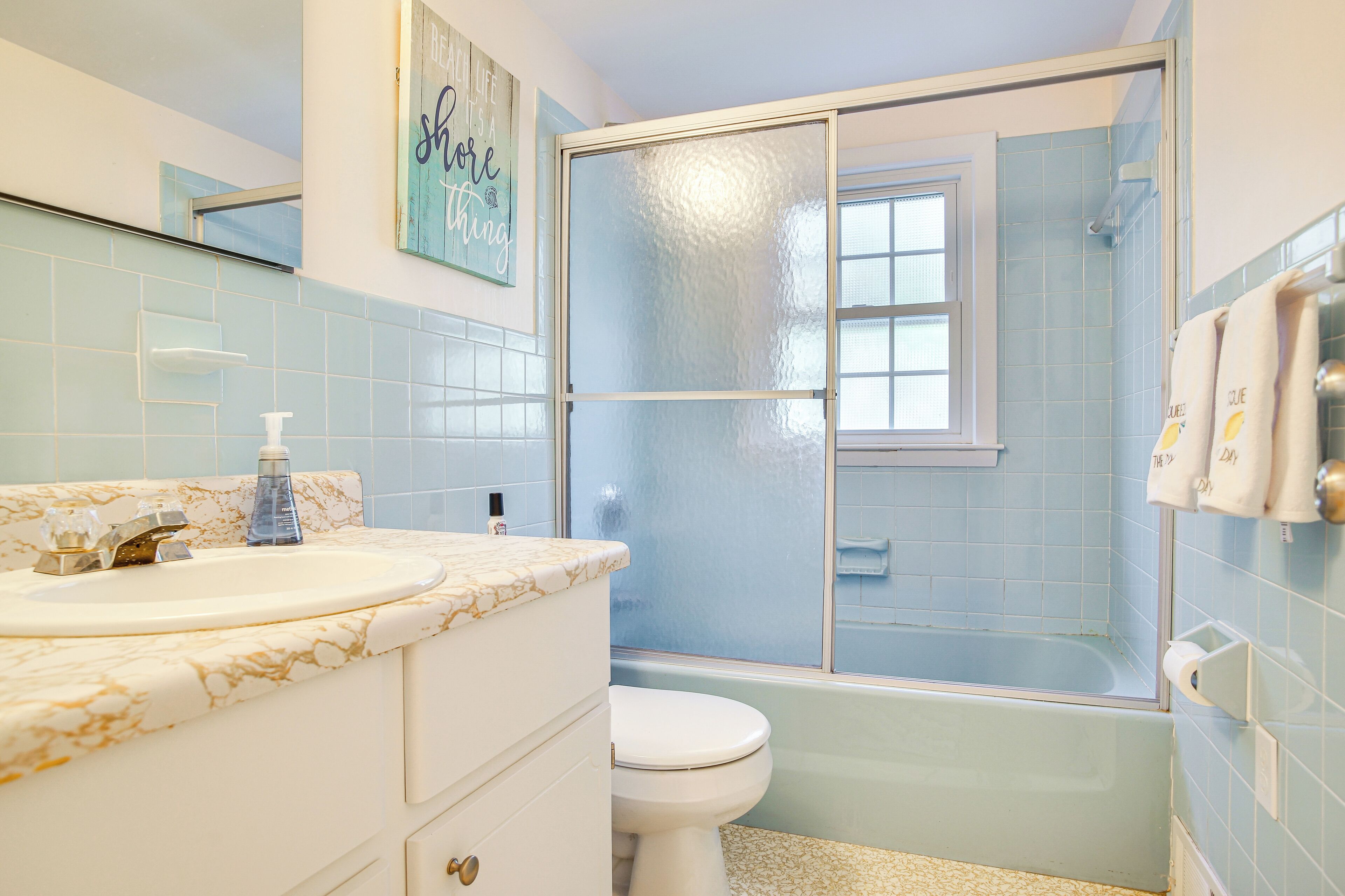 A bathroom with a white sink, a toilet, and a glass-enclosed shower area.
