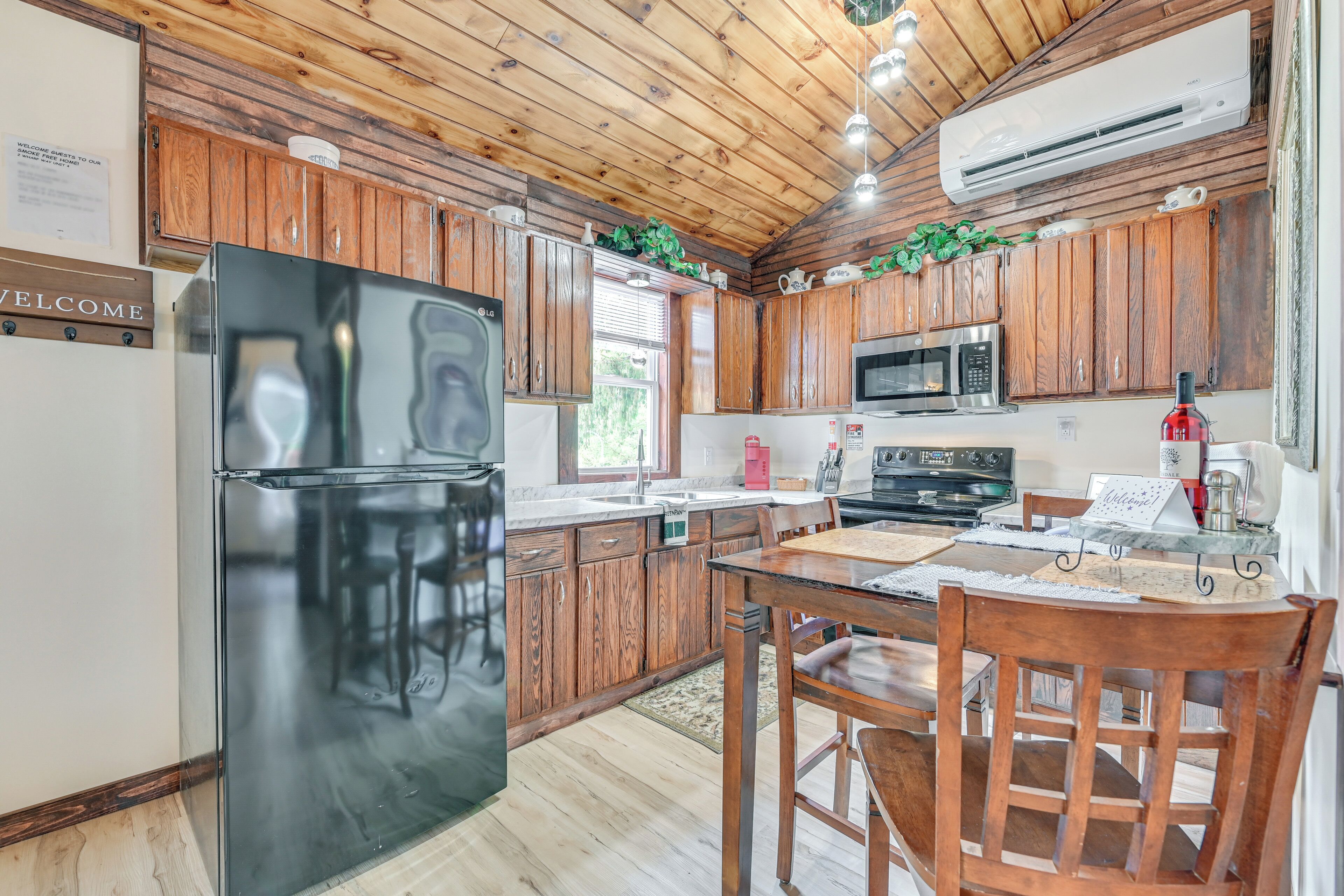 A kitchen with wooden cabinets, a black refrigerator, a microwave, and a stove.