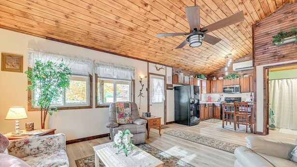 A spacious living area with a wooden ceiling, a dining area, and a kitchen with modern appliances. - 2 Mi to Lake Champlain: Cabin w/ River Access! (Peru)