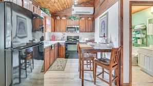 A compact kitchen with wooden cabinets, a stainless steel refrigerator, a microwave, and a stove. - 2 Mi to Lake Champlain: Cabin w/ River Access! (Peru)